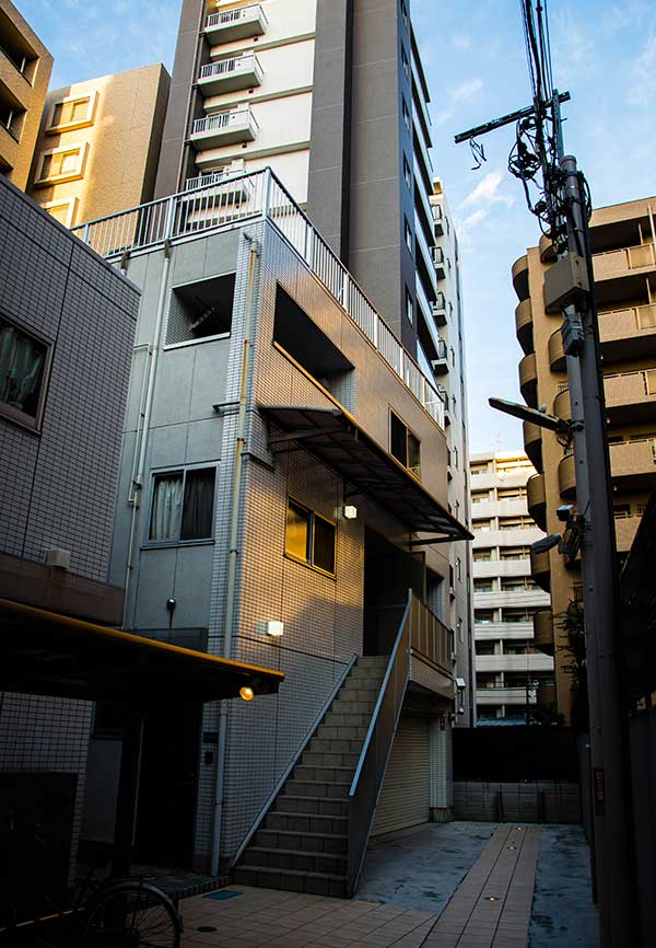 A modern apartment block, surrounded by tall buildings